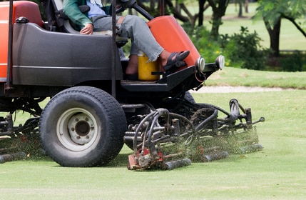 Bertrand Pneus distribue des pneus Man Worker riding mower machine cutting fairway.